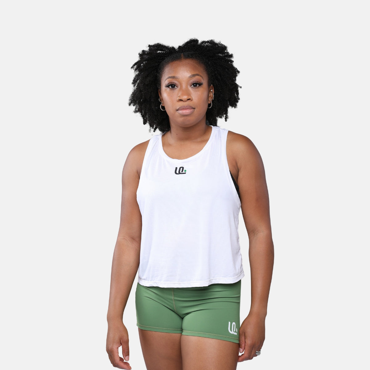 Woman wearing a white tank top and green shorts with Unsponsored Life logo 